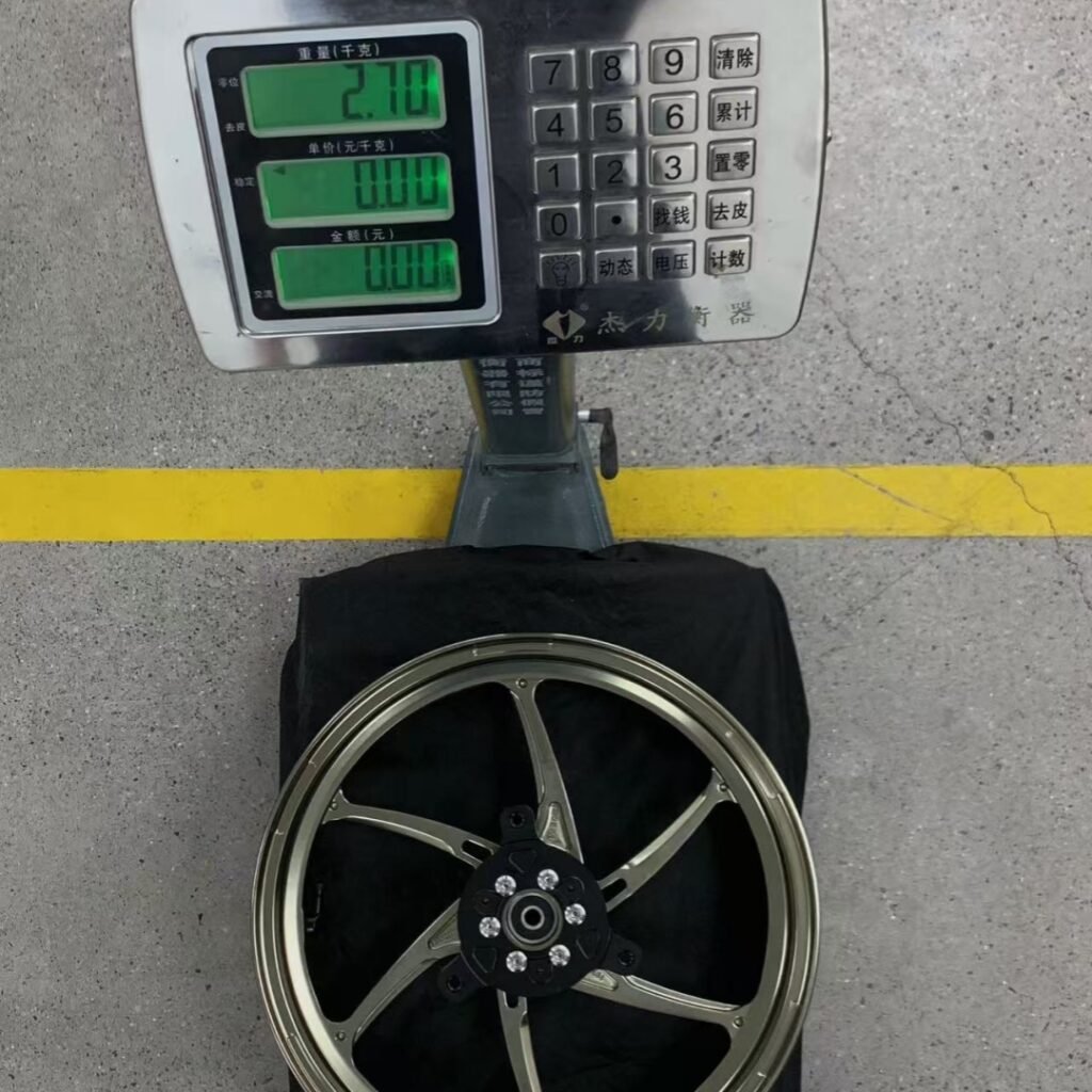 Weight reading 2.7kg for NVX155 front forged aluminum wheel in gold finish on scale