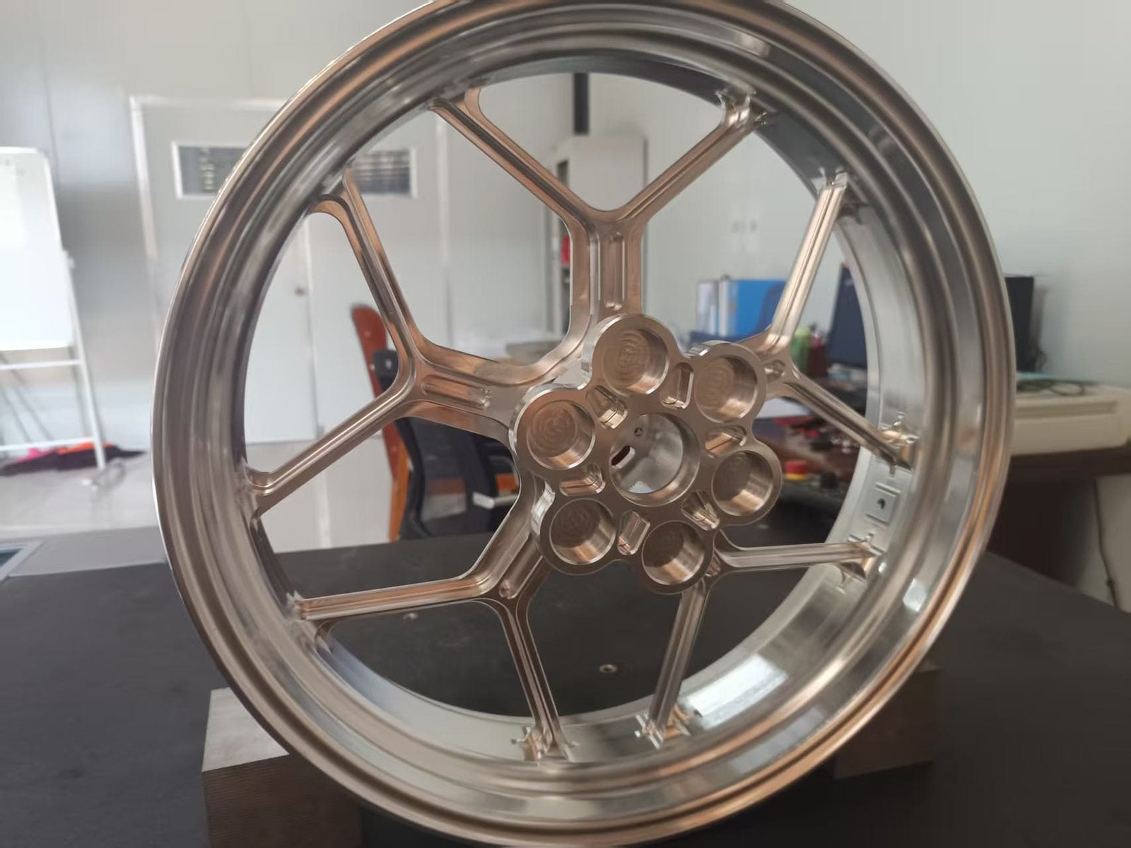 Inspecting the protective coating on a magnesium forged motorcycle wheel at FLEXIMOTO quality control