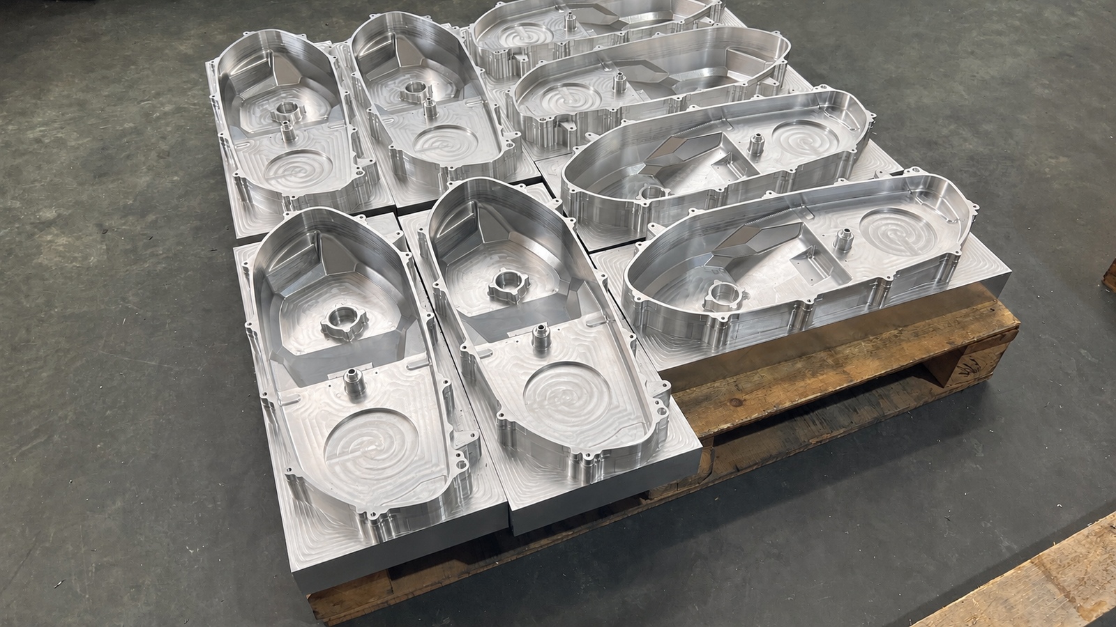 Scooter CVT covers machined from solid aluminum plate, still on their stock blocks