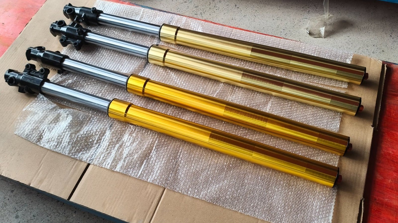 Custom motorcycle front forks with gold anodized tubes, made to spec for FLEXIMOTO